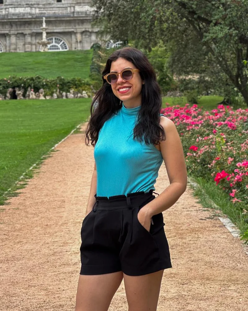 Marcela en los jardines del Palacio Real de Madrid, con camiseta turquesa y pantalón corto negro