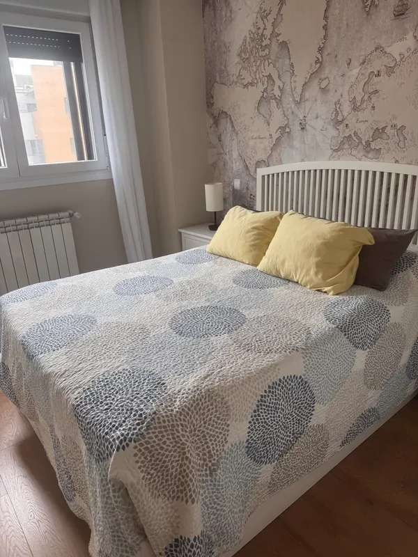 Dormitorio con la cama hecha y cojines amarillos